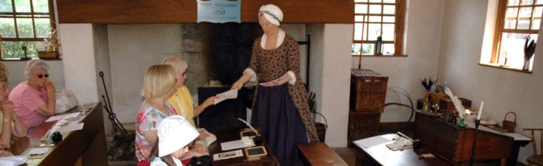 A group of tourists participating in a school house reenactment